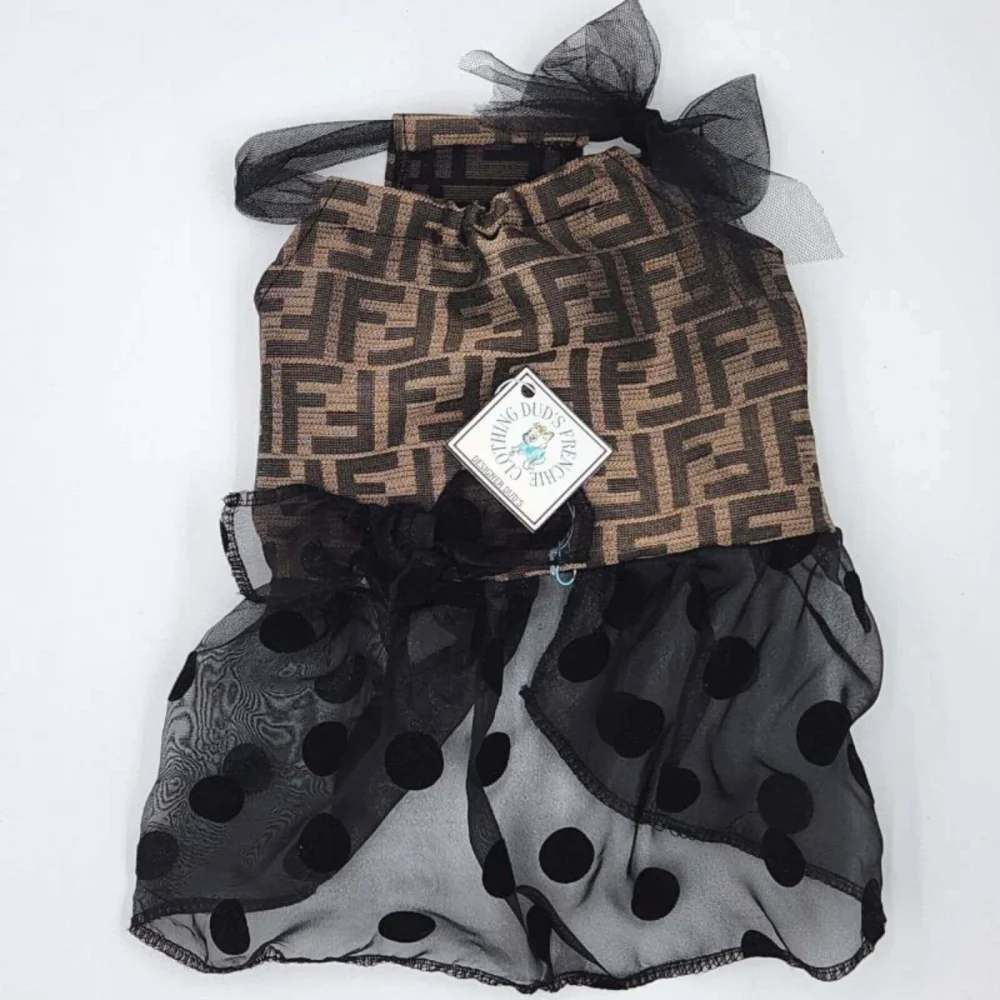 Indulge your furry fashionista in the world of elegance and playfulness with the Fendi Dress. Featuring an upper adorned with iconic FF pattern in black and brown, and a skirt adorned with black mesh and velvet polka dots, this dress is a masterpiece of charm and whimsy. Celebrate your pup's unique style and the unbreakable bond you share with this exquisite ensemble.4